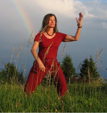 (c) Christopher Calliess Hannelore Calliess macht Qigong im Freien, im Hintergrund ein Regenbogen